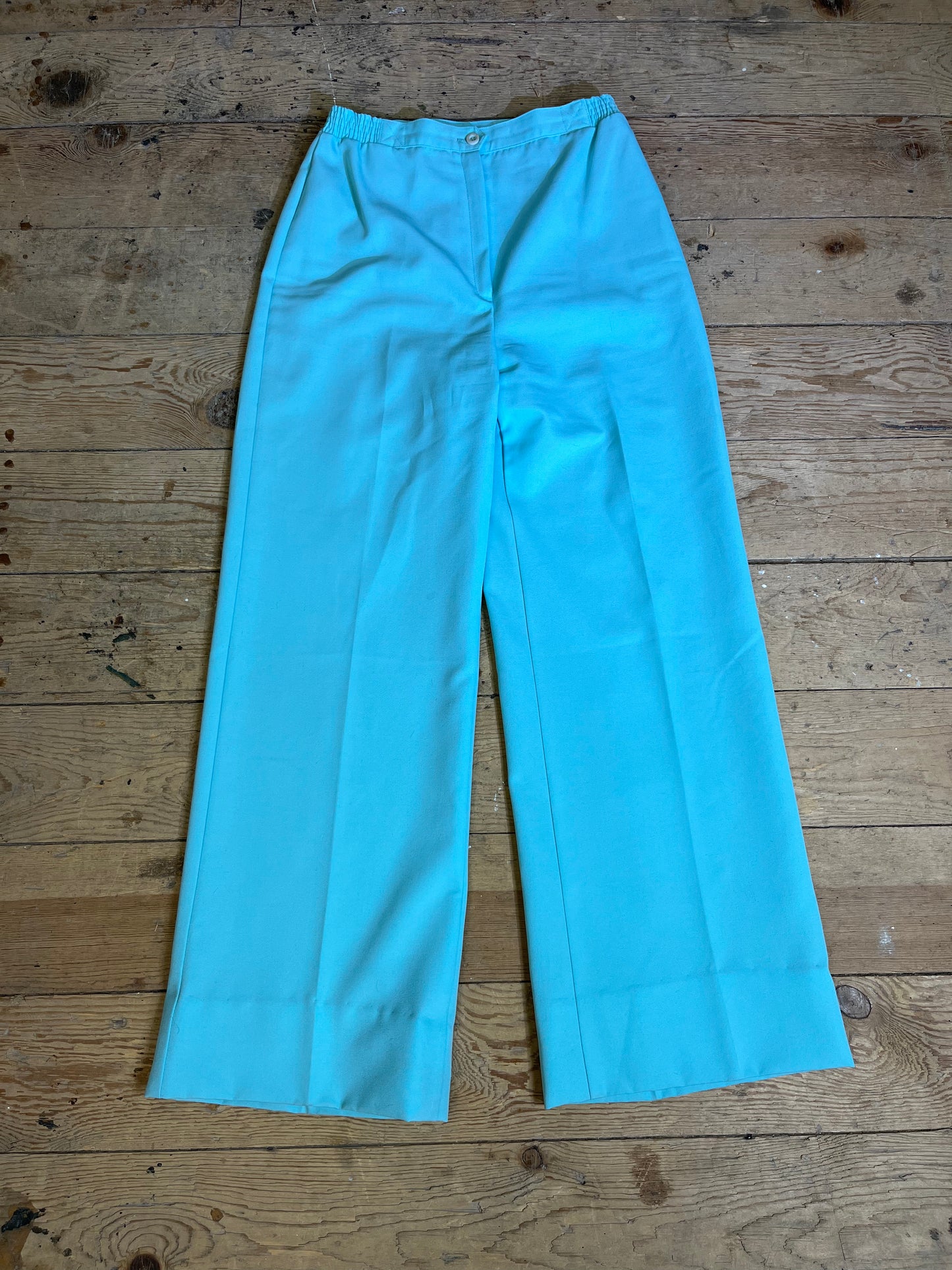 1970s High Rise Seafoam Teal Trousers - Front View: Elevate your style with vintage-inspired elegance. Seafoam teal high-rise trousers with zipper and button clasp detail.