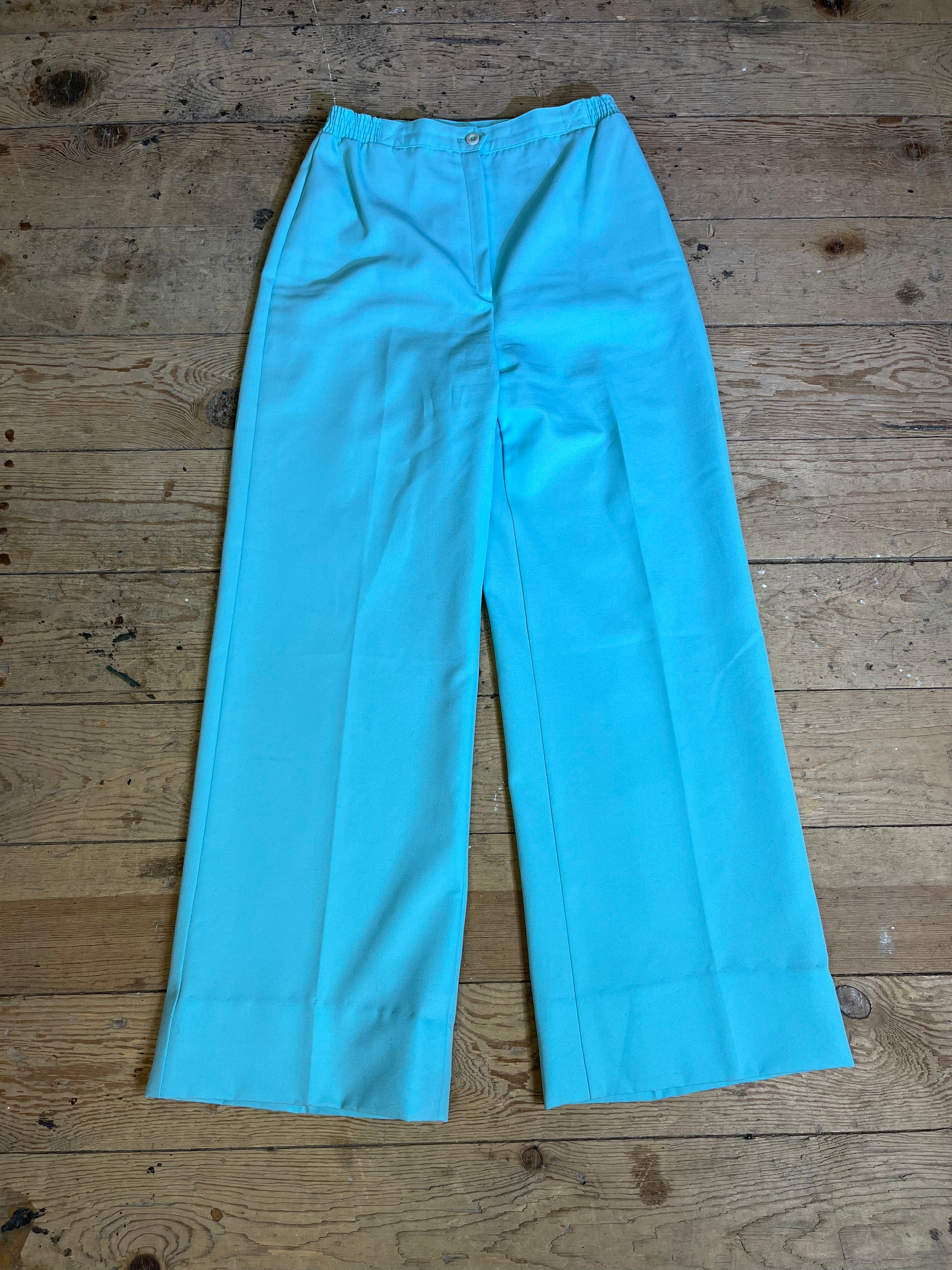 1970s High Rise Seafoam Teal Trousers - Front View: Elevate your style with vintage-inspired elegance. Seafoam teal high-rise trousers with zipper and button clasp detail.