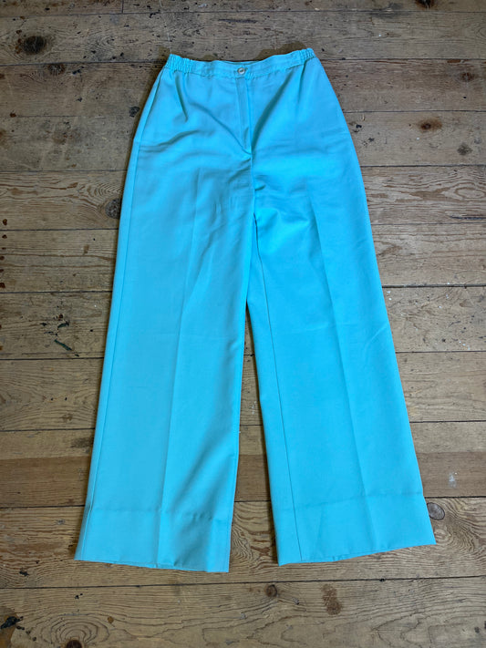 1970s High Rise Seafoam Teal Trousers - Front View: Elevate your style with vintage-inspired elegance. Seafoam teal high-rise trousers with zipper and button clasp detail.