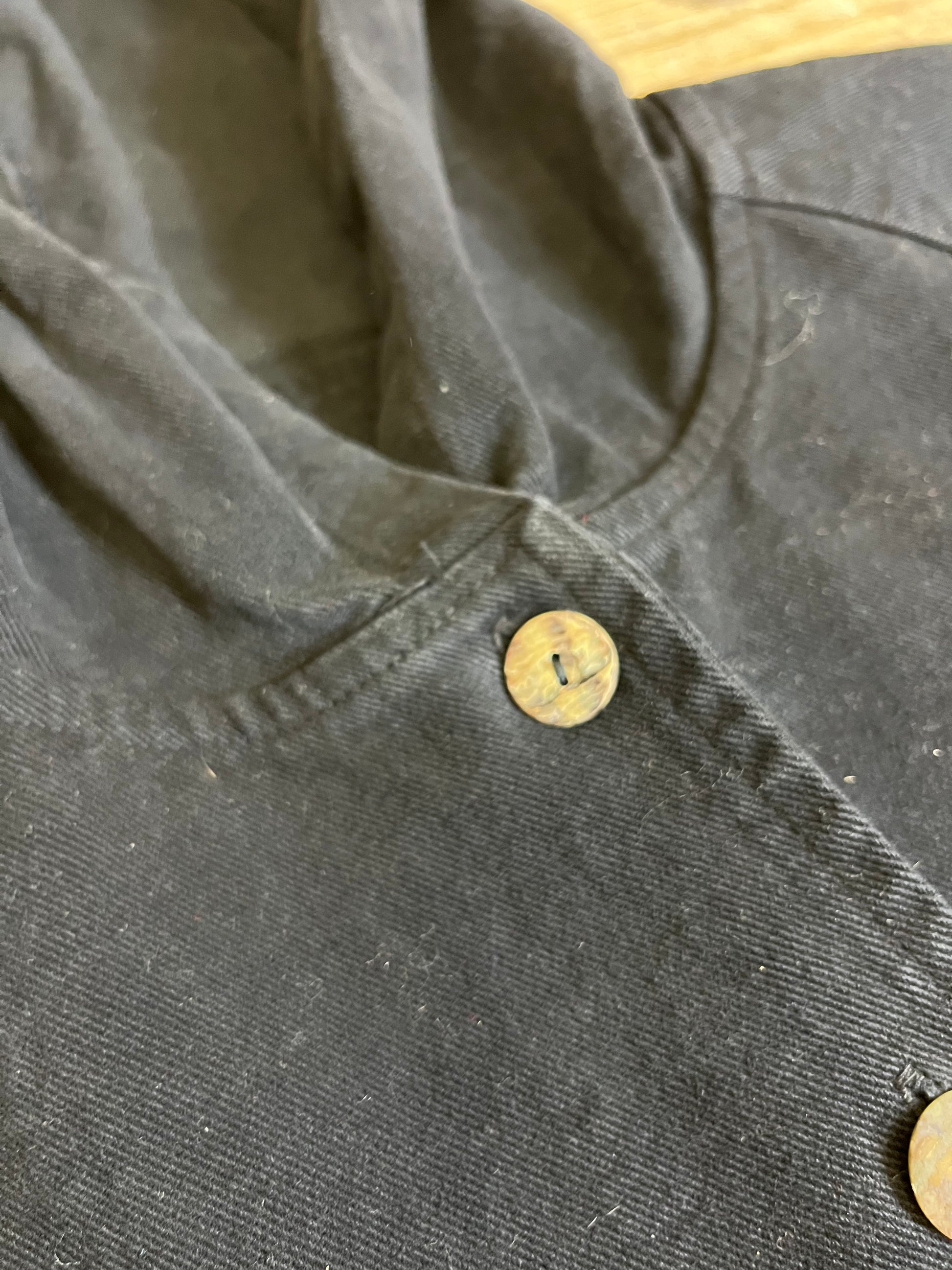 "Close-up view of Vintage Black Trench Coat neckline and buttons. Exquisite details showcase classic elegance and sophisticated button-up design."