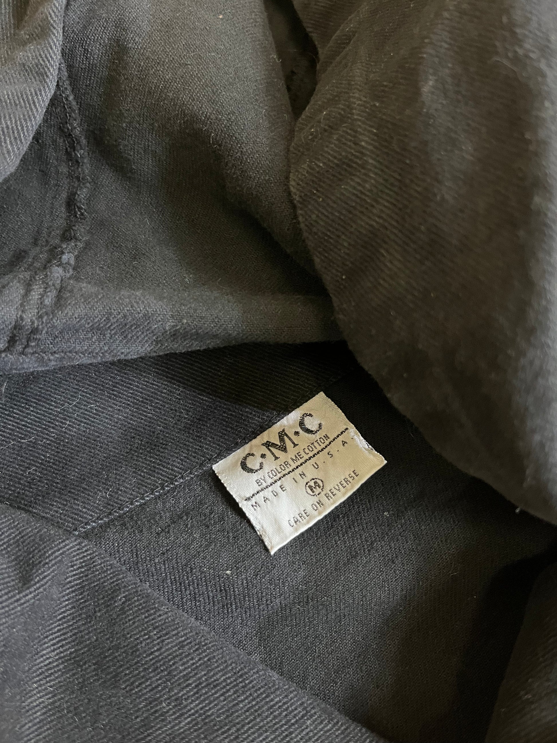  "Color me Cotton clothing tag on Vintage Black Trench Coat. Brand tag with logo, adding a touch of authenticity and quality to the classic design."