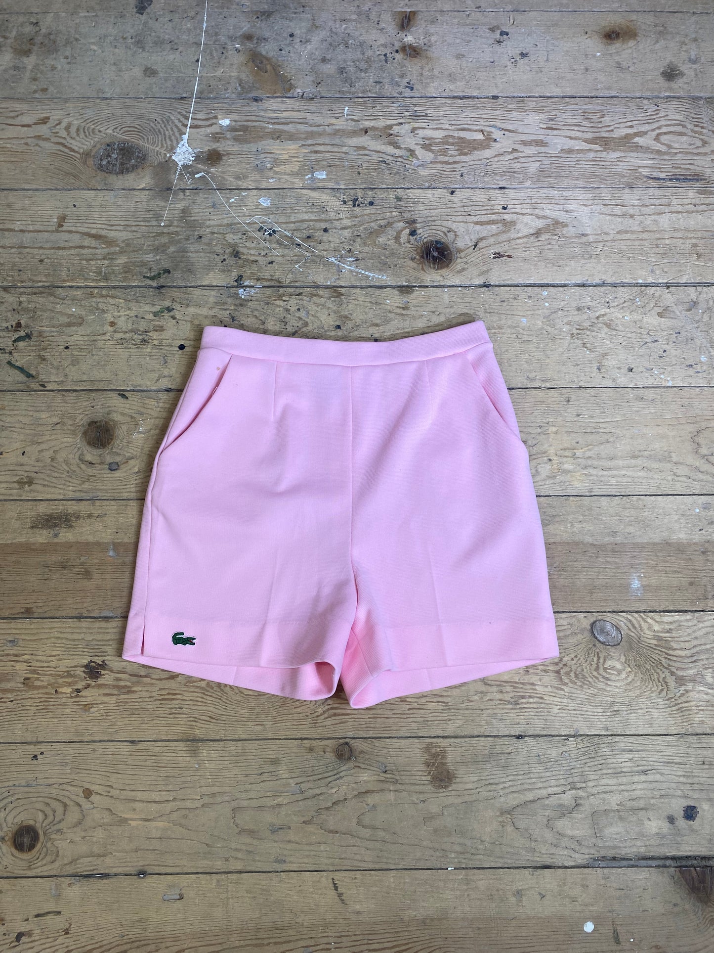 "Vintage High-Waisted Pink Shorts by Haymaker Lacoste: A front view showcasing the flattering cut, delightful pink hue, and unique patch detail on the right thigh."