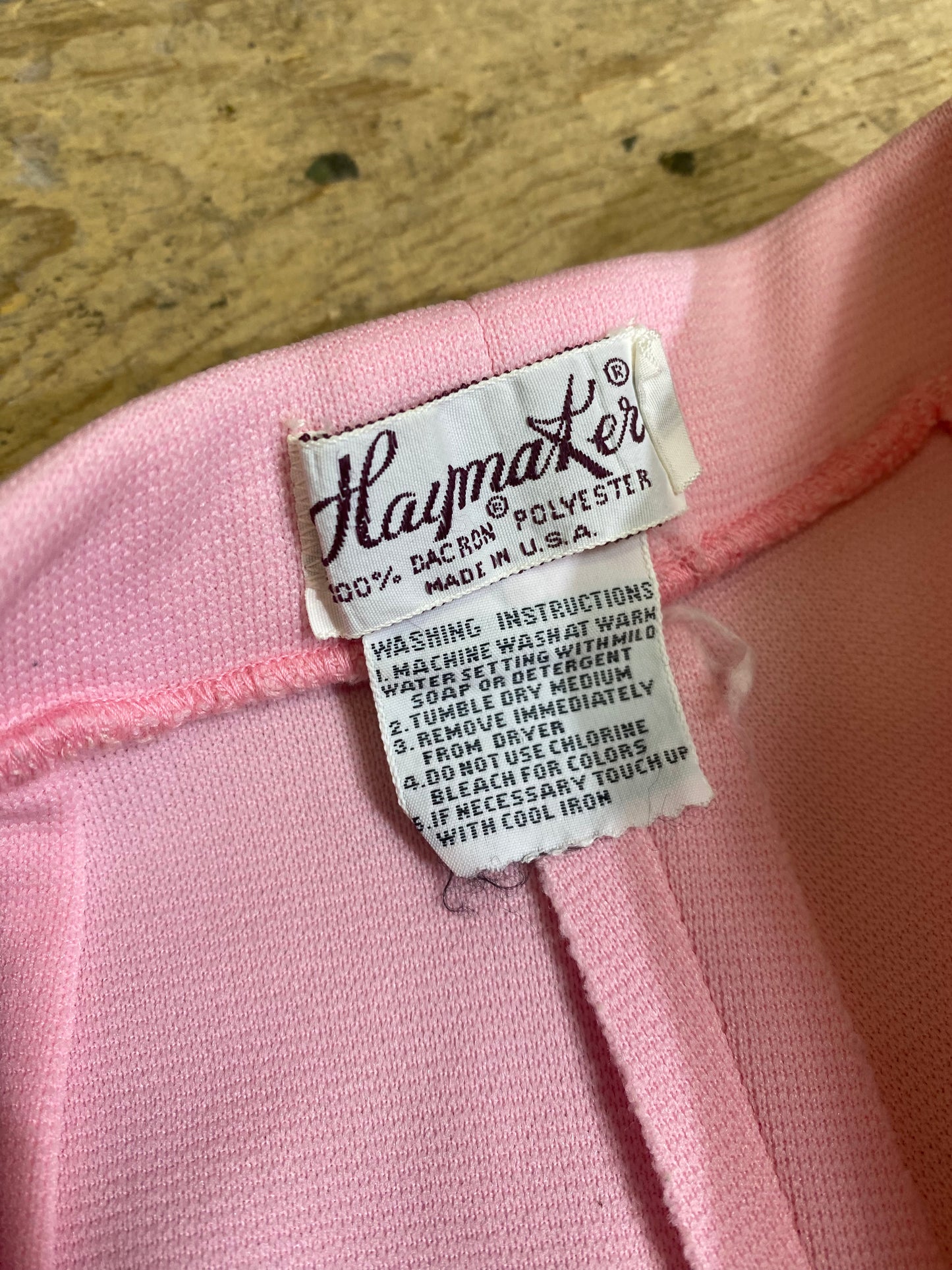 "Close-up of the Haymaker Lacoste tag on Vintage High-Waisted Pink Shorts, showcasing the brand's signature detailing for a touch of authenticity and style."